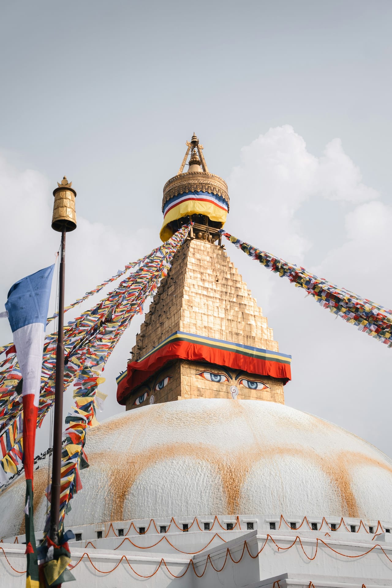 Boudhanath Stupa in Kathmandu with prayer flags against a blue sky