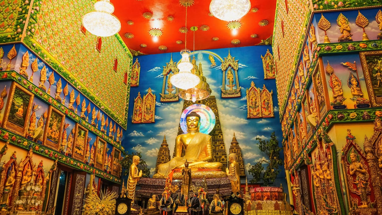 Golden Buddhas in the painted hall of a Thai temple