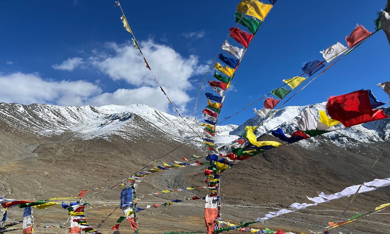 Tibetan prayer flags strung before snow-capped peaks